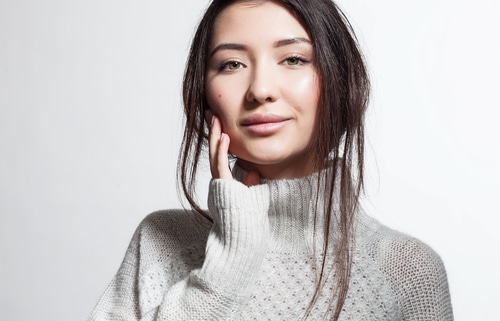 Pretty smiling woman with clean skin in white fluffy sweater