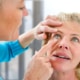 A doctor examining a woman’s eyes for signs of cataracts