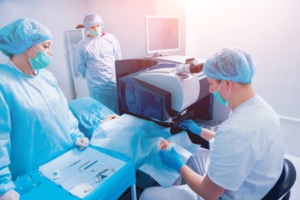 Surgical room with multiple nurses and an ophthalmologist performing bladeless LASIK surgery using IntraLase FS.
