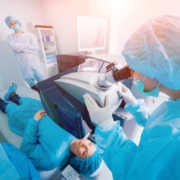 Room-wide image of a patient having LASIK eye surgery performed by her ophthalmologist.