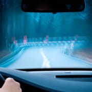 Point-of-view of someone driving at night and struggling with glare and blurry vision, in need of cataract surgery
